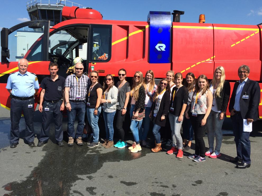 Rhine-Waal students pose in front of the fire engine of the Airport Weeze’s fire and rescue service.
