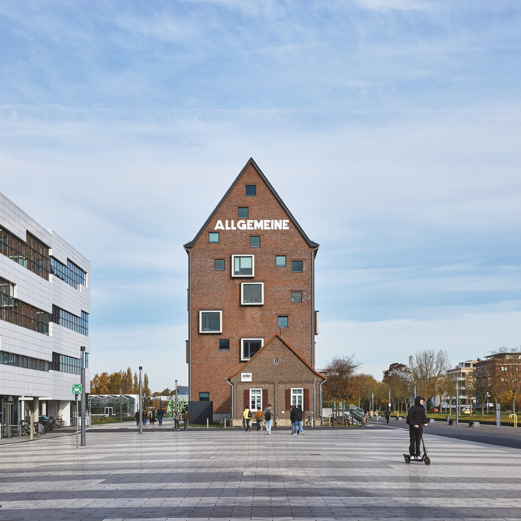 Der Campus Kleve mit Fokus auf die Bibliothek die im alten Hafenspeicher ist, daneben sind moderne Gebäude.