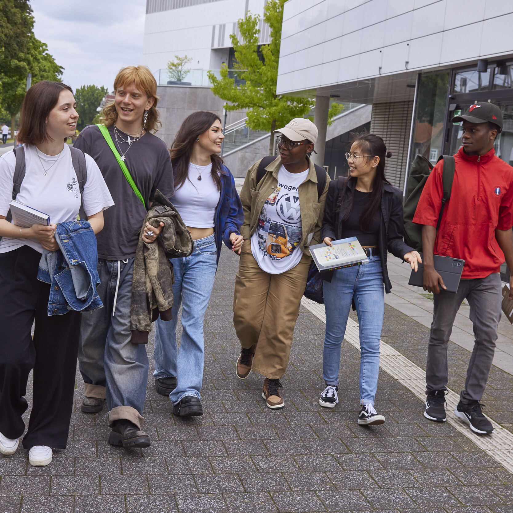 Eine Gruppe Studierender läuft über den Campus