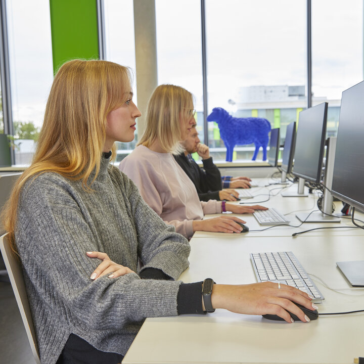 Zwei Studentinnen arbeiten an Computerarbeitsplätzen in einem modernen Computerlabor.