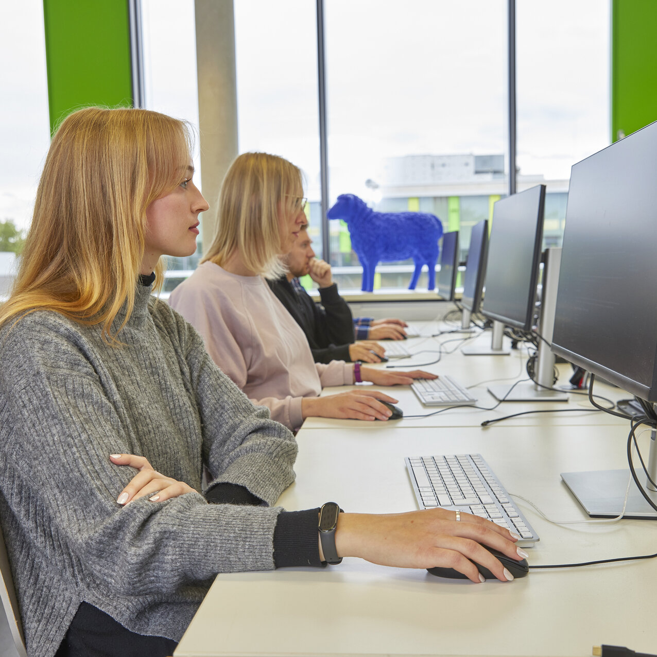 Zwei Studentinnen arbeiten an Computerarbeitsplätzen in einem modernen Computerlabor.