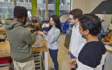 Dein Master für Zukunftsjobs Vier Studierende stehen gemeinsam im FabLab und beschäftigen sich mit einer praktischen Aufgabe.