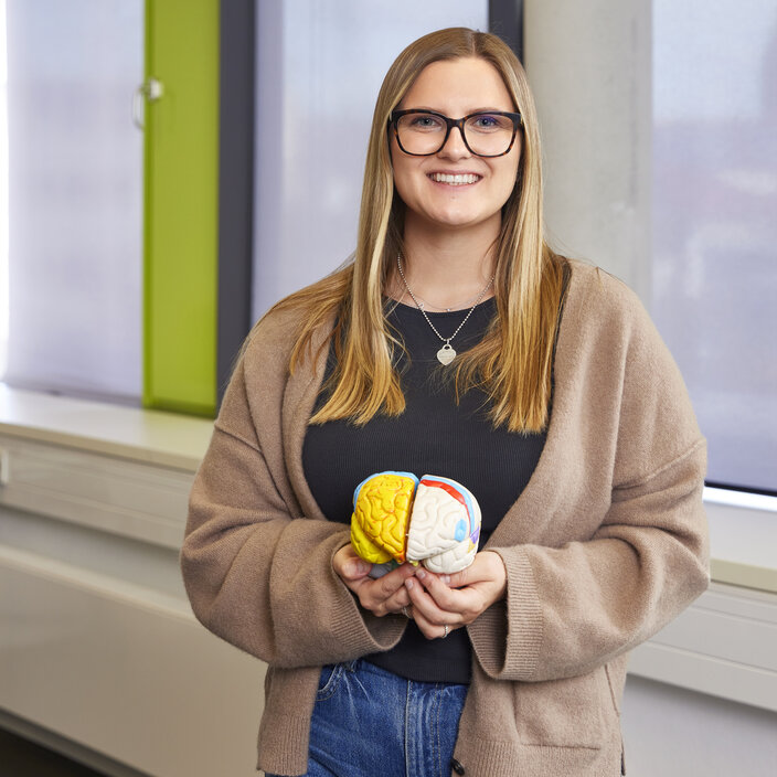 Portrait of Emely Höpken holding a model of a brain