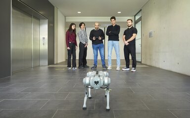 Zukunft aktiv mitgestalten Roboterhund im Hochschulgebäude wird von Studierenden im Hintergrund gesteuert