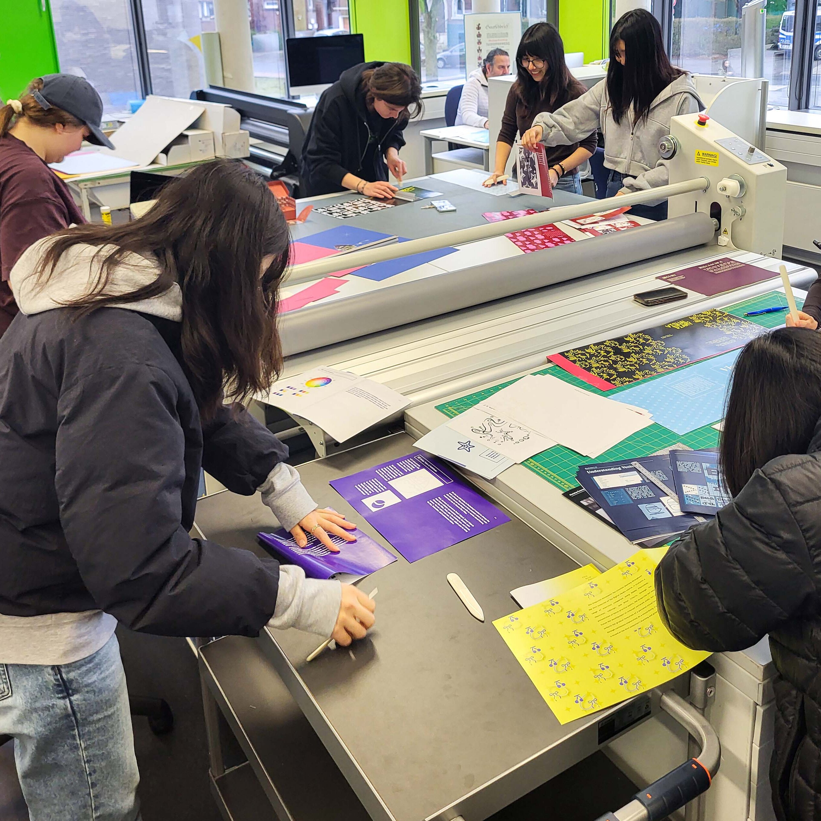 Studierende arbeiten am Tisch in der Designwerkstatt