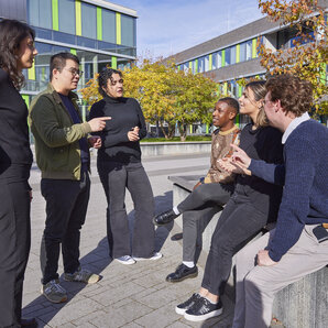 Eine Gruppe von Studierenden im Gespräch auf dem Campus