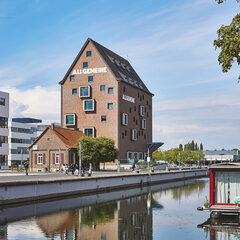 Spoy-Kanal, dahinter das Gebäude der Bibliothek; ein hohes Gebäude aus Backstein mit Giebeldach