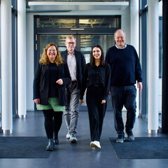 Four people are walking down the corridor at Rhine-Waal University of Applied Sciences. They make up the SBV committee.