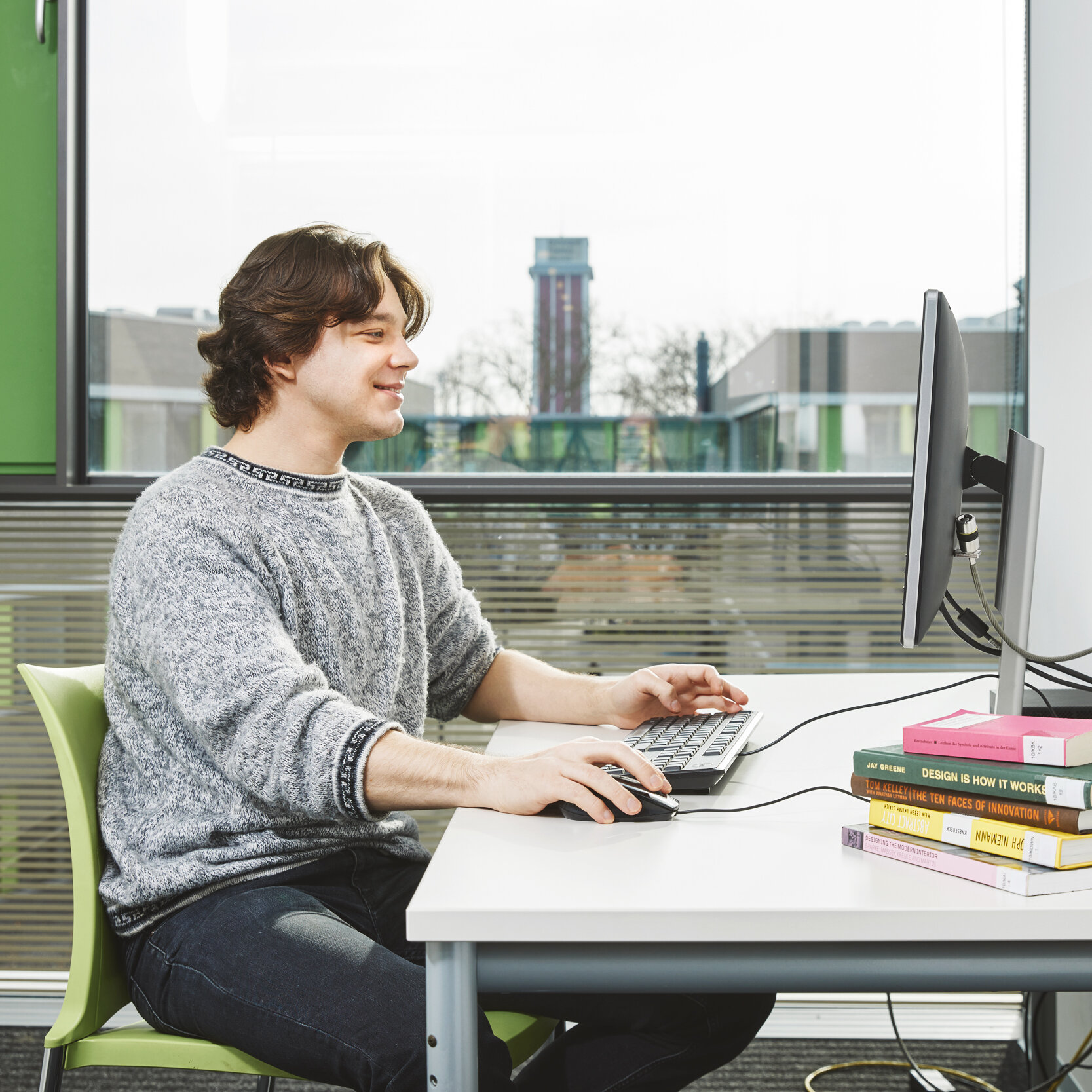 Student arbeitet in einem Einzelarbeitsraum der Bibliothek Kamp-Lintfort an einem Bibliothekscomputer