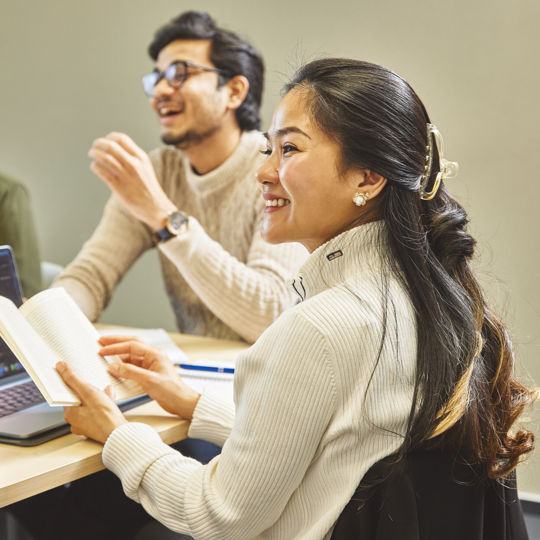 Zwei Studierende lachen im Gruppenarbeitsraum der Bibliothek in Kleve