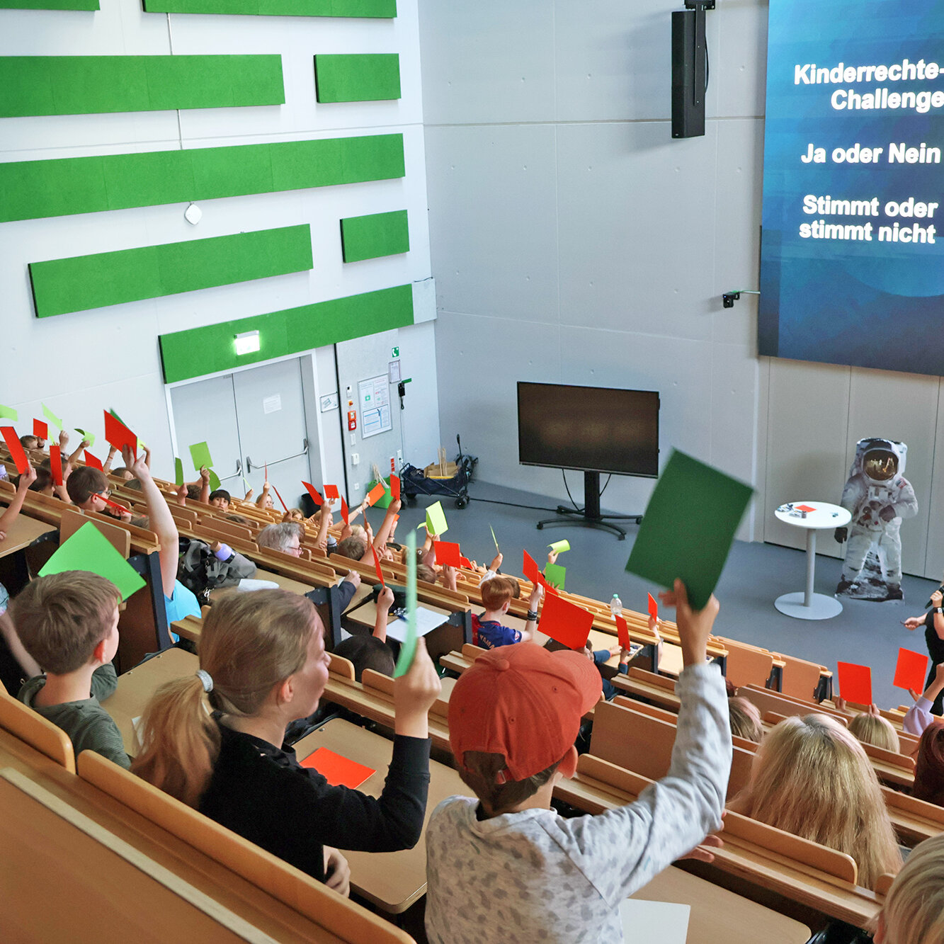 Kinder beteiligen sich an einer Abstimmung im Hörsaal