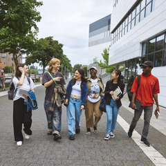 Eine Gruppe Studierender auf dem Campus ins Gspräch verteift