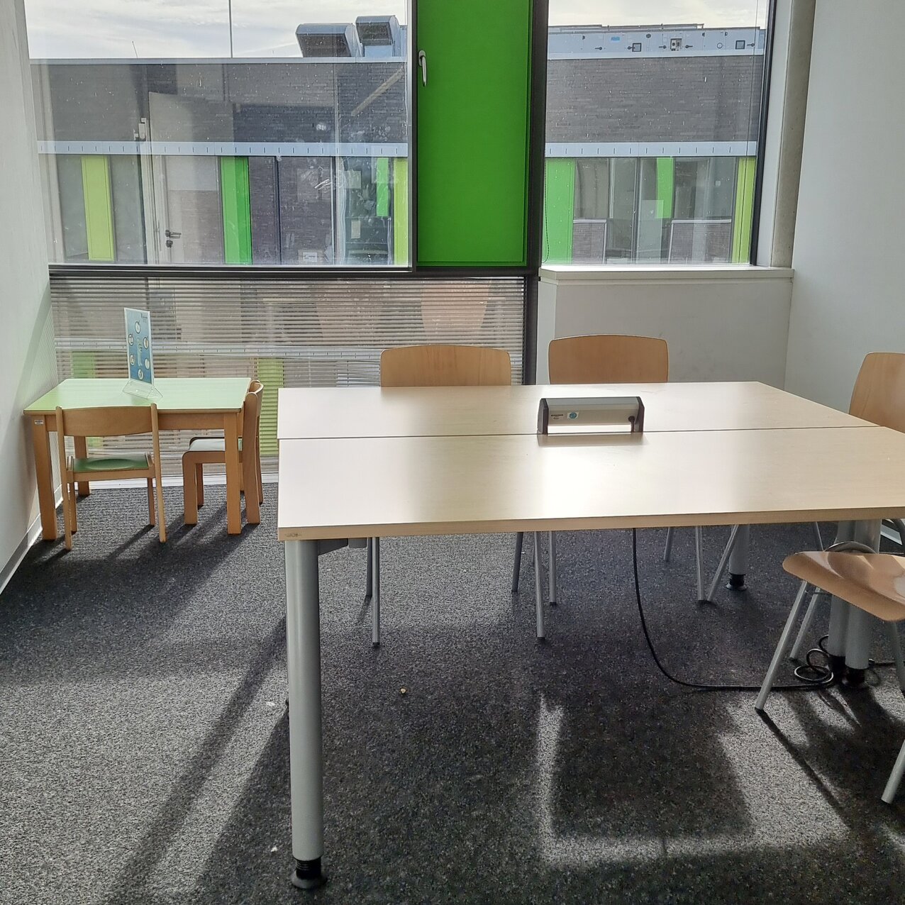 Eltern-Kind-Raum in der Kamp-Lintforter Bibliothek mit einem großen Gruppentisch sowie einem Tisch und Stühlen für Kinder