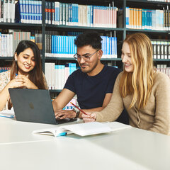 Drei Studierende sitzen in der Bibliothek Kamp-Lintfort und lernen gemeinsam