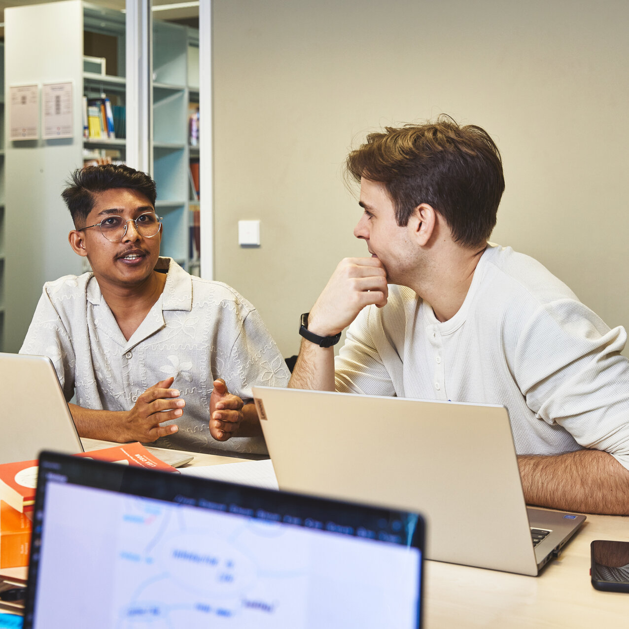 Zwei Studierende lernen gemeinsam in einem Gruppenarbeitsraum der Bibliothek Kleve