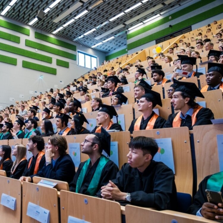 Das Foto zeigt die Absolvent*innen im Hörsaal