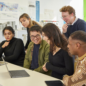 Fünf Studierende arbeiten gemeinsam an Laptops und Tablets