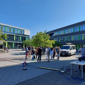 Studierende und Mitarbeiter der Bundesnetzagentur auf dem Campus führen Messungen durch