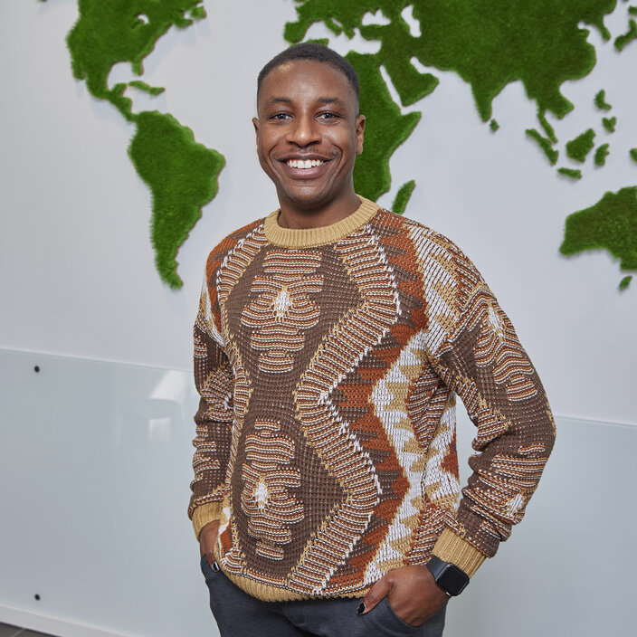 Tinashe Mukombe aus Simbabwe Portraitbild Tinashe Mukombe vor einer Landkarte