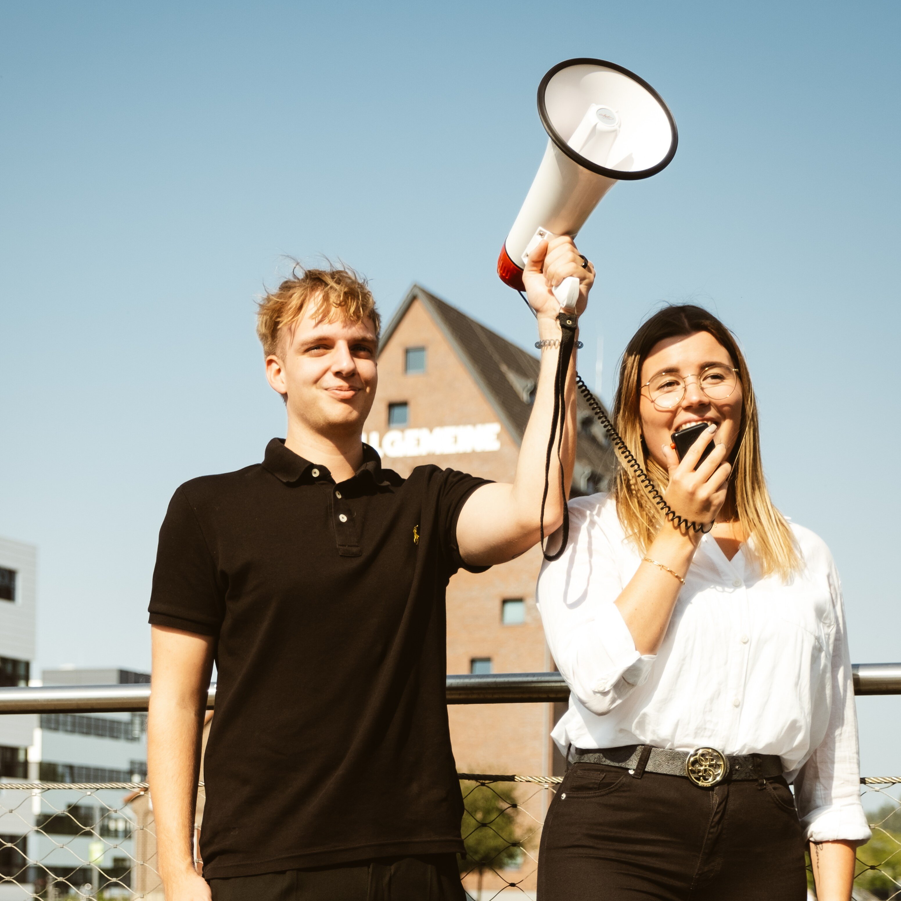 2 Auszubildende am Campus mit Megafon
