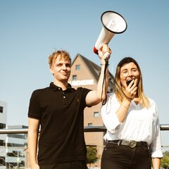 2 Auszubildende am Campus mit Megafon