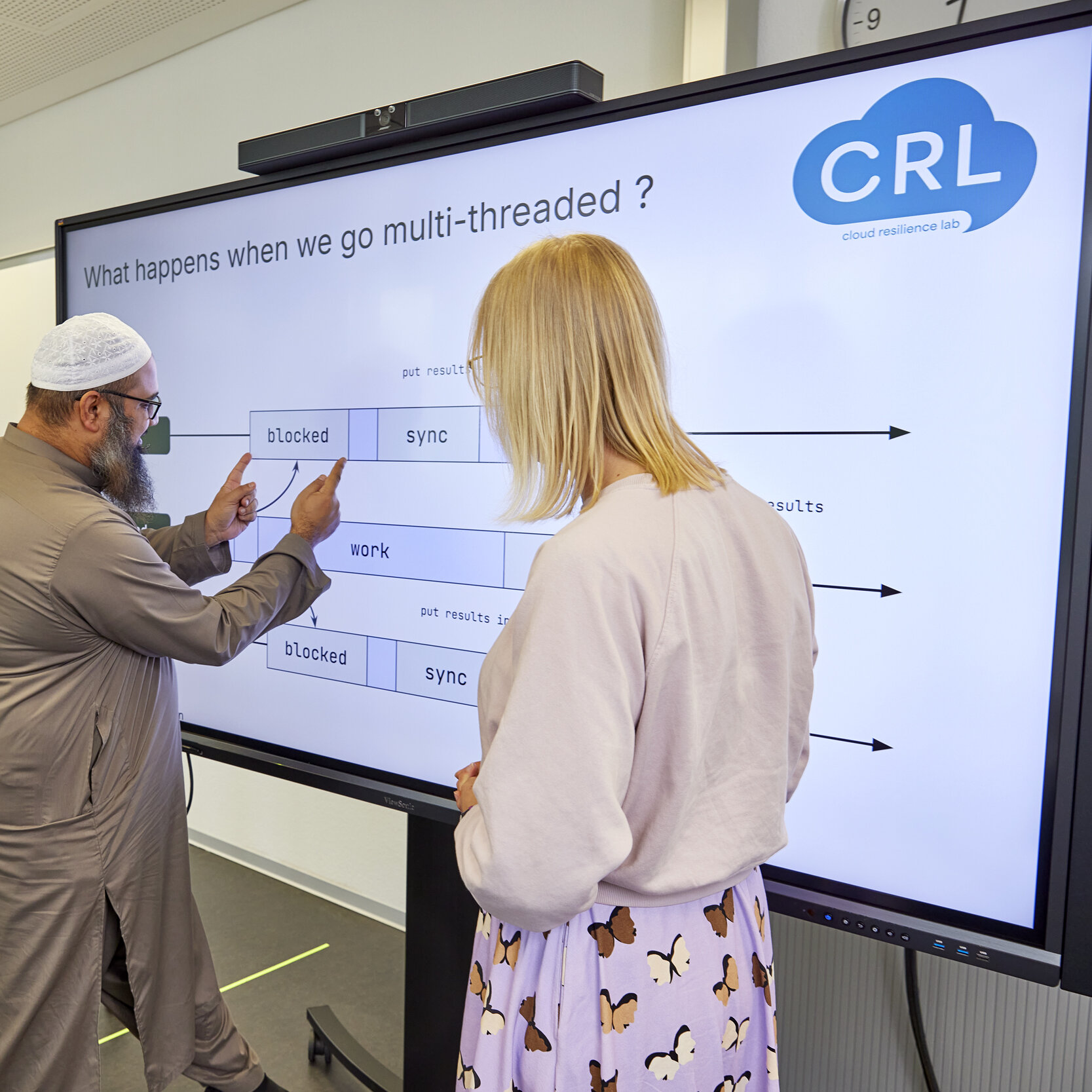  Drei Personen arbeiten gemeinsam an einem großen interaktiven Bildschirm im Cloud Resilience Lab.