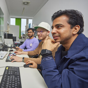 Drei Studierende arbeiten an Computerarbeitsplätzen im Computerlabor.