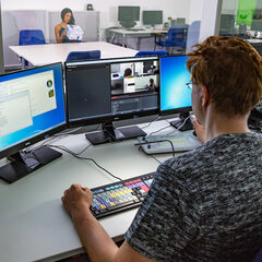 A person is working on a computer in the control room
