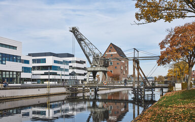 Der Campus Kleve mit Blick auf die Bibliothek, dem Spoykanal und dem ehemaligen Hafenkran bei herbstlichem Wetter.