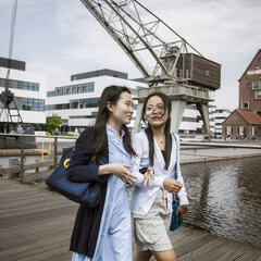 Two female students are crossing the bridge on the Kleve campus
