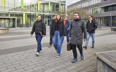 Zukunftssicher studieren Eine Gruppe von Studierenden geht über den Campus.