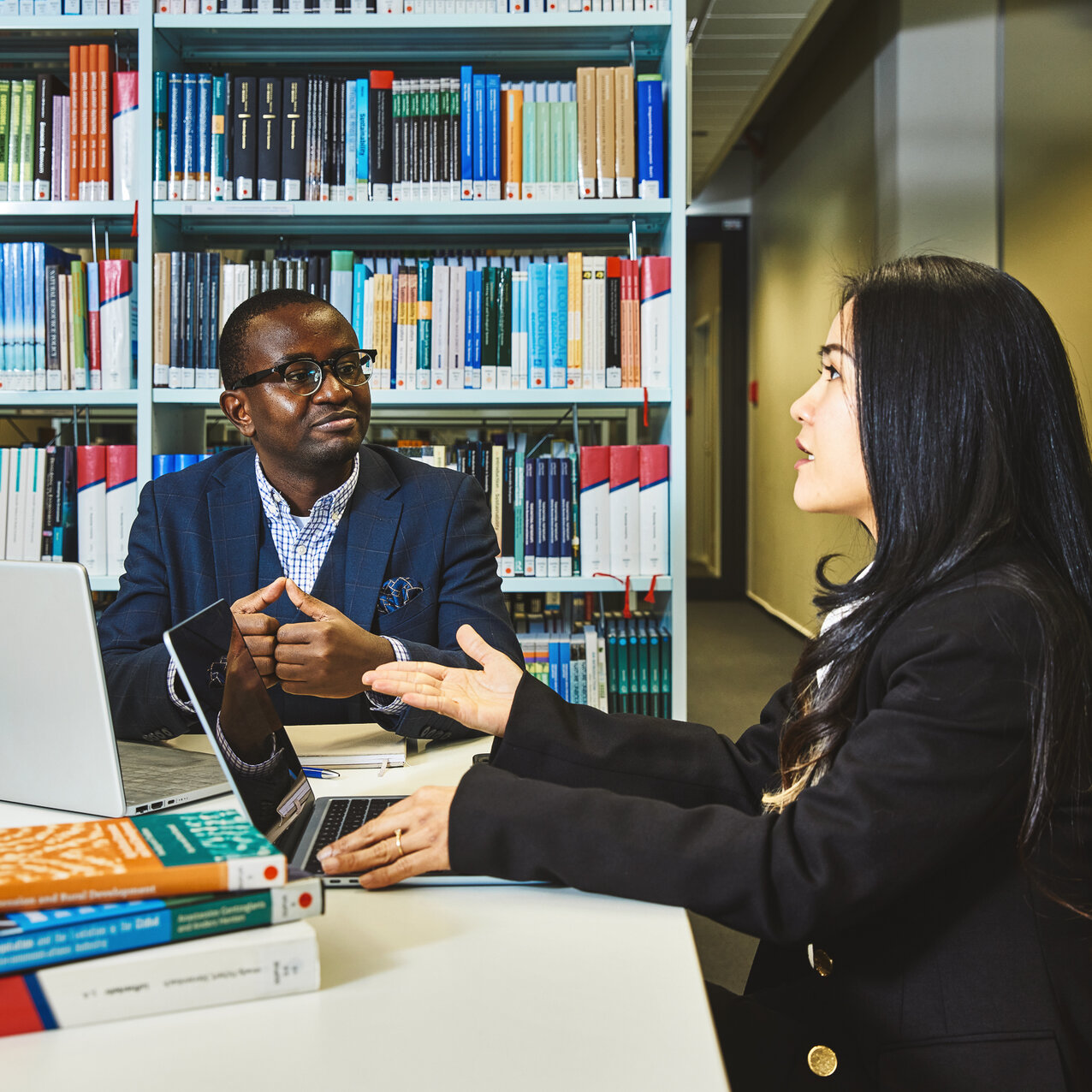 Zwei Studierende sitzen in der Bibliothek Kleve und diskutieren