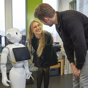Zwei Studierende mir Roboter "Pepper"