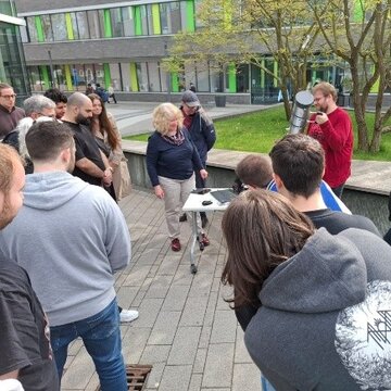 Studierende mit einem einfachen Hohlleiter, dem „Ofenrohr“, auf dem Campus