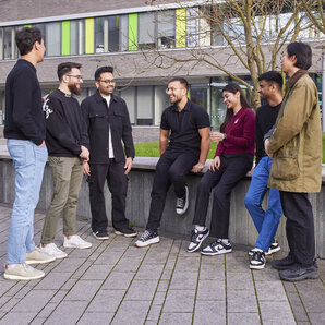 Eine Gruppe Studierender unterhält sich auf dem Campus