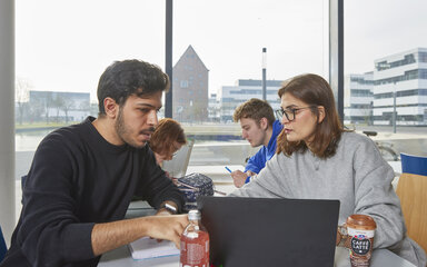 Zwei Studierende arbeiten zusammen an einem Laptop