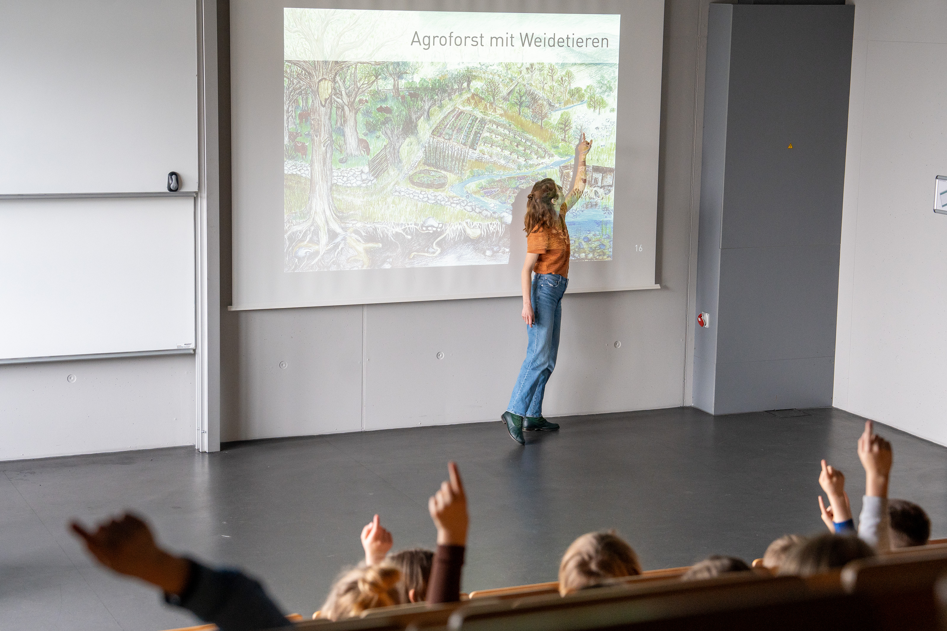 Eine Doktorandin im Agroforst Reallabor des Projektes TransRegINT mit Grundschüler*innen beim Nachhaltigkeitscoaching zum Thema Agroforst an der HSRW  