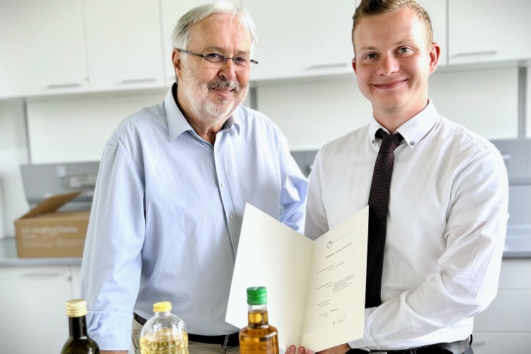 Im Labor: Nachwuchspreisträger Kilian Visser, M.Sc., wissenschaftlicher Mitarbeiter und Doktorand an der Fakultät Life Sciences (links), steht neben Prof. Dr. Dr. Manfred Gareis, dem Vorsitzenden des Stiftungskuratoriums der Heinrich-Stockmeyer-Stiftung, und hält lächelnd seine Auszeichnung in die Kamera.