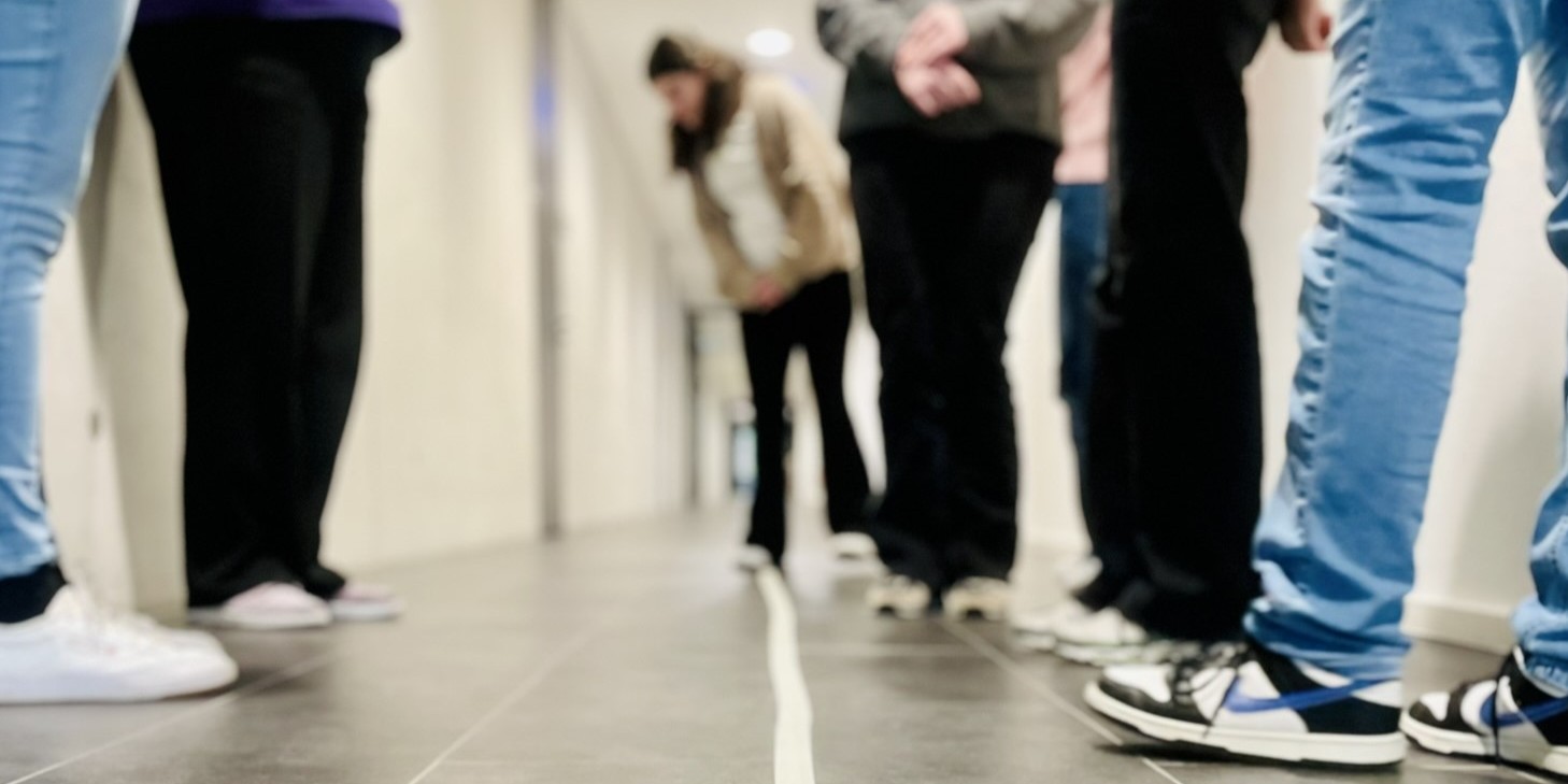 Schülerinnen und Schüler schauen sich Infos zu Studiengängen an Stellwänden und lassen sich von Professoren beraten.