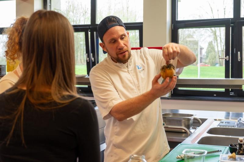 Der Koch Joel Büns präsentiert Zuschauenden eine Frucht