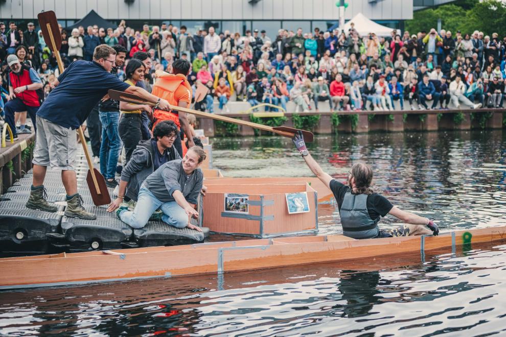 Schwanenritter-Race beim HSRW-Campusfest - vor vollbesetzten Rängen am Wendebecken vor der Mensa auf dem Campus Kleve lassen die Teilnehmenden ihre selbst gebauten Boote zu Wasser