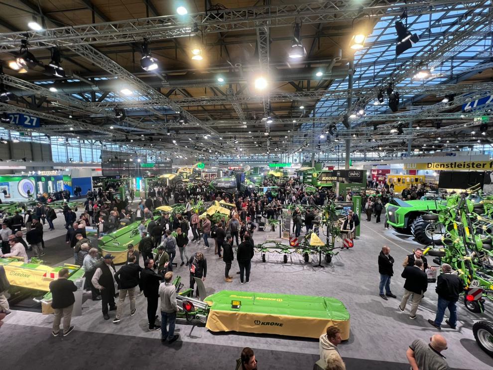 Dieses Bild bietet einen weiten Blick auf die Ausstellungshalle der Agritechnica, gefüllt mit Teilnehmern, Ständen und Maschinen.