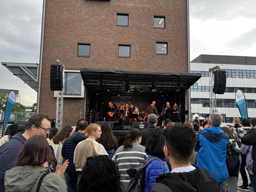 Eine große Bühne mit der Professorenband "Orange Green", die beim Campusfest auftritt.