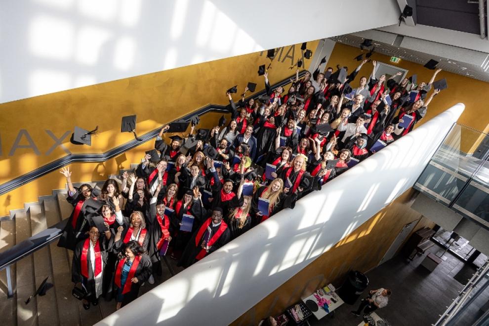 Abschlußfoto mit alles Absolvent*innen auf der Treppe