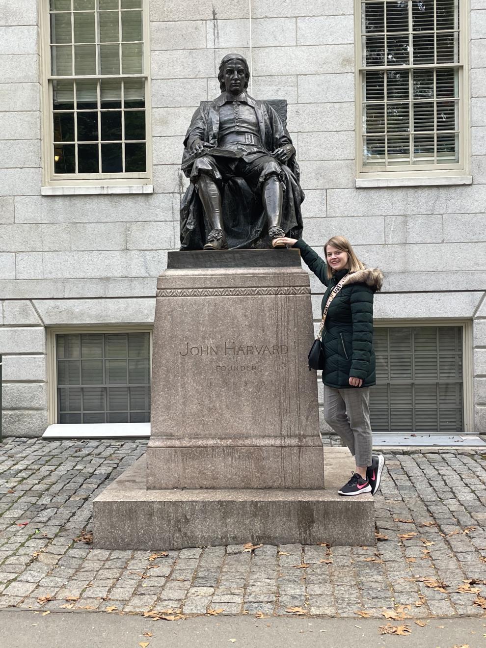 Eine Junge Frau neben einer Statue von Havard