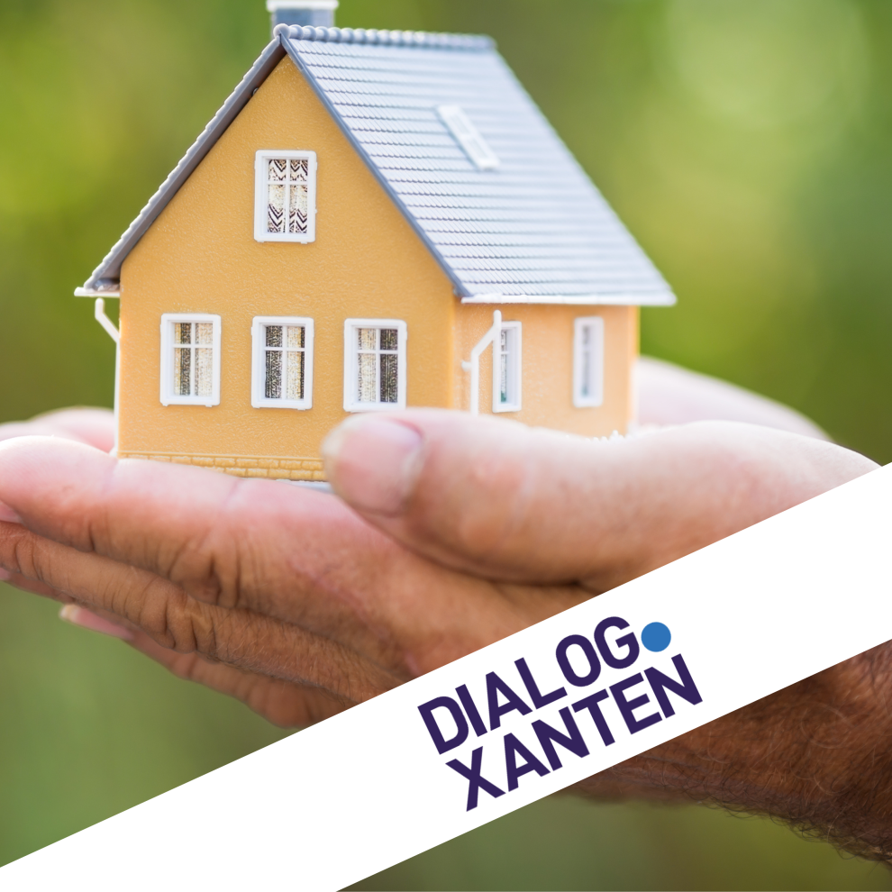 Ein kleines Modellhaus wird in 2 Händen gehalten.