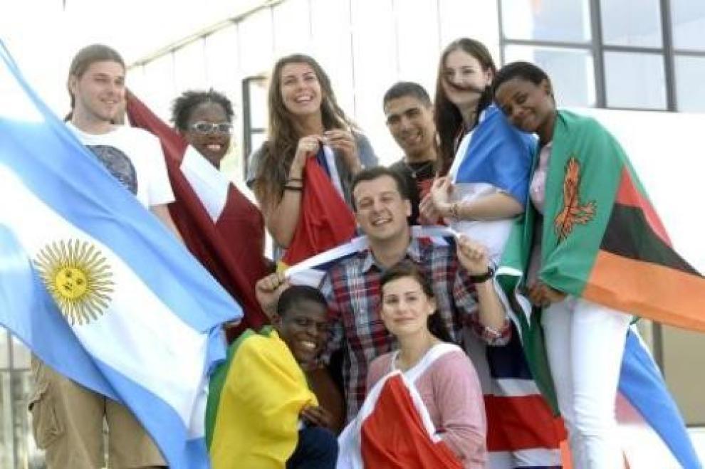 Mehrere Personen halten unterschiedliche Länderfahnen.