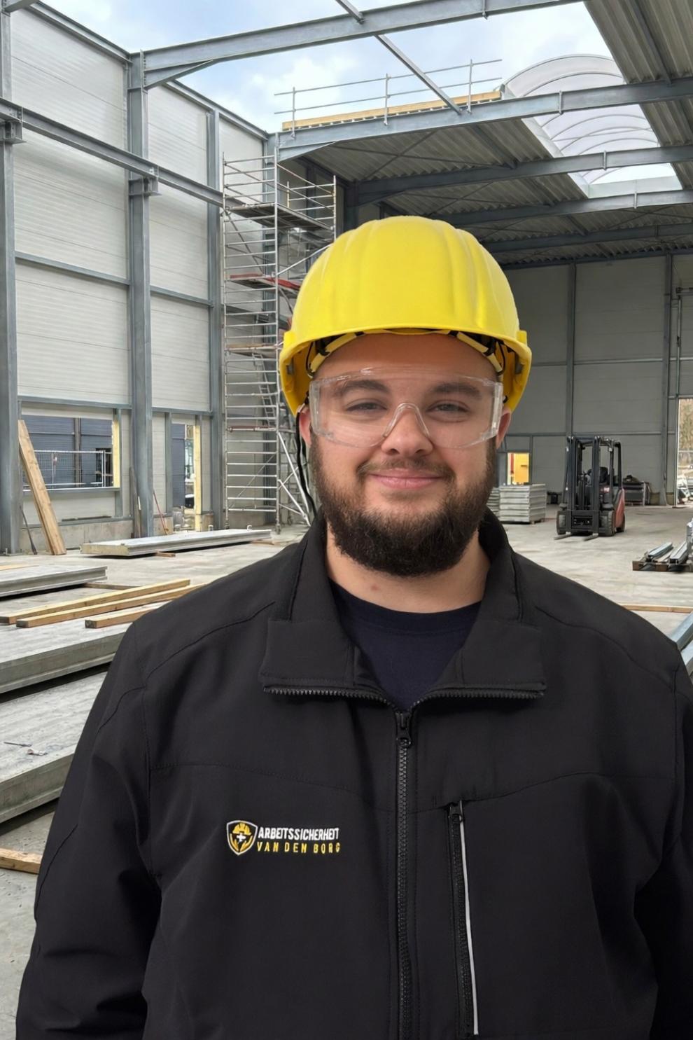 Sicherheitsingenieur Sebastian van den Borg auf einer Baustelle mit Helm